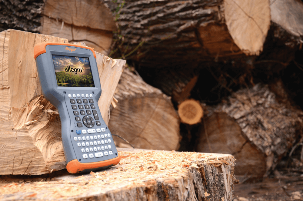 Display of the Allegro Rugged Handheld keyboard on a wooden log.
