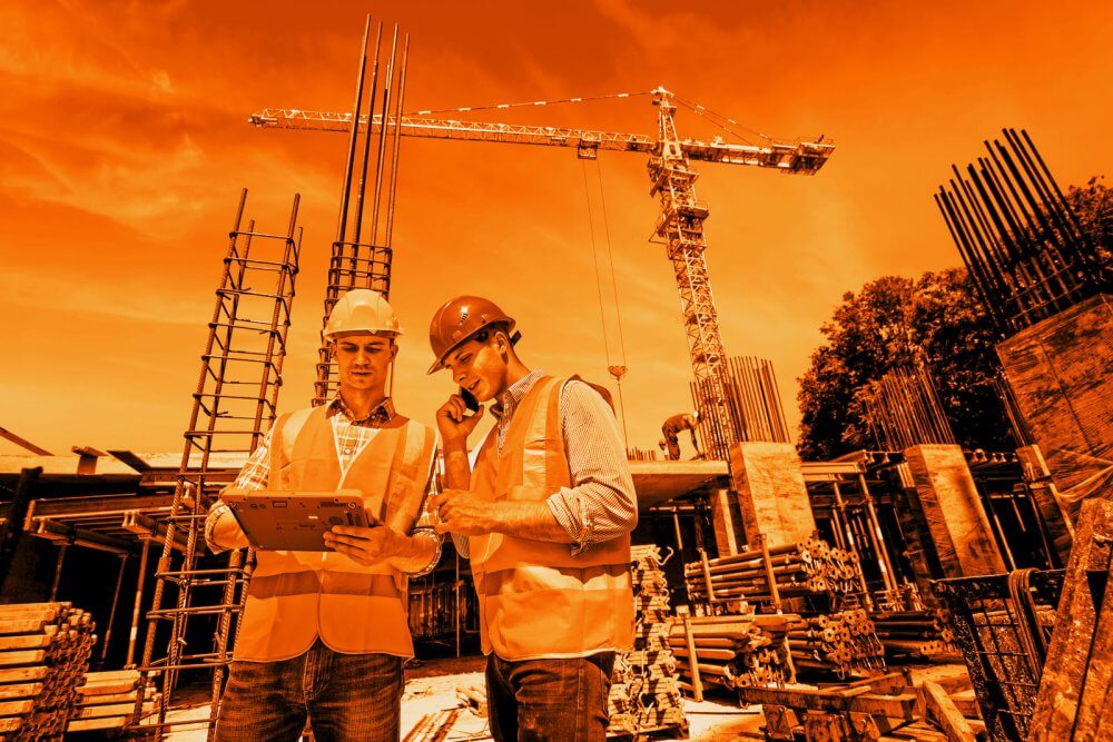 Two workers using a rugged mobile device for construction